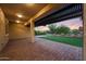 Covered patio with brick flooring, overlooking a well-manicured backyard at 18835 W San Miguel Ave, Litchfield Park, AZ 85340