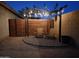 Outdoor seating area with wooden pergola, decorative rocks, and privacy fencing at 2004 N 108Th Dr, Avondale, AZ 85392