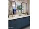 Stylish bathroom vanity with double sinks, modern fixtures, and elegant blue cabinetry at 2004 N 108Th Dr, Avondale, AZ 85392