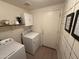 Functional laundry room with washer, dryer, and storage shelves for added convenience at 2004 N 108Th Dr, Avondale, AZ 85392