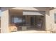 Cozy outdoor patio space with comfortable seating and roll down sun shade at 2004 N 108Th Dr, Avondale, AZ 85392