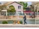 Scenic view with a person walking a dog next to water and beautiful homes at 2004 N 108Th Dr, Avondale, AZ 85392