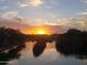 Stunning sunset over the water, reflecting vibrant colors across the landscape at 2004 N 108Th Dr, Avondale, AZ 85392
