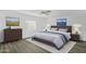 This bedroom features a white ceiling fan, a window, wood furniture and decor for staging at 211 N 7Th St, Avondale, AZ 85323