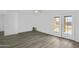 Bright living room features light gray flooring and access to the backyard through white framed glass doors at 211 N 7Th St, Avondale, AZ 85323