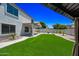 Backyard view of artificial turf, xeriscaping, and covered patio at 2881 E Estrella Ct, Gilbert, AZ 85296