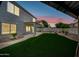 Lush backyard with artificial turf, mature plants, and an outdoor covered patio at 2881 E Estrella Ct, Gilbert, AZ 85296