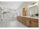 Bright bathroom featuring double vanities, modern fixtures, patterned tile floors, soaking tub, and glass shower at 2881 E Estrella Ct, Gilbert, AZ 85296