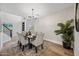 Elegant dining room with a modern chandelier, seating for six, and wood flooring at 2881 E Estrella Ct, Gilbert, AZ 85296