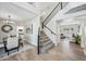 Grand entryway featuring a staircase with dark iron railing, light wood floors and views into dining and living spaces at 2881 E Estrella Ct, Gilbert, AZ 85296