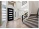 Inviting entryway featuring a staircase, dark front door, high ceilings, and light wood flooring at 2881 E Estrella Ct, Gilbert, AZ 85296