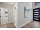 Bright foyer features modern black door with sidelights, light wood floors, and an abstract blue painting on the wall at 2881 E Estrella Ct, Gilbert, AZ 85296