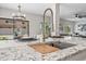 Close-up of a kitchen island, featuring a prep sink, marble countertops, and modern decor at 2881 E Estrella Ct, Gilbert, AZ 85296