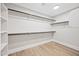 Walk in closet with preinstalled hanging rods and storage shelves on a light hardwood floor at 2881 E Estrella Ct, Gilbert, AZ 85296