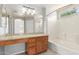 Bathroom featuring granite counter, wood cabinets, tub, and window at 3050 E Pontiac Dr, Phoenix, AZ 85050