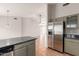 Open-concept kitchen with stainless steel refrigerator, grey cabinets, granite counters, and terracotta tile floors at 3050 E Pontiac Dr, Phoenix, AZ 85050