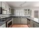 Kitchen featuring gray cabinetry, granite counters, stainless steel appliances, and a window with plantation shutters at 3050 E Pontiac Dr, Phoenix, AZ 85050