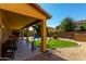 A covered patio overlooks backyard features including synthetic lawn, desert landscaping, BBQ, and swimming pool at 3080 E Andre Ave, Gilbert, AZ 85298