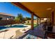 The covered patio has a view of the pool, manicured lawn and desert landscaping in the backyard at 3080 E Andre Ave, Gilbert, AZ 85298