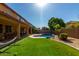 Home featuring a gorgeous backyard swimming pool, desert landscaping, synthetic lawn, and covered patio at 3080 E Andre Ave, Gilbert, AZ 85298