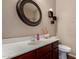 Well-lit half bathroom featuring a modern sink, toilet, and decorative mirror at 3080 E Andre Ave, Gilbert, AZ 85298