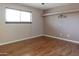 Bedroom features a large window with blinds, wood-look floors, and neutral paint at 3345 E University Dr # 2, Mesa, AZ 85213