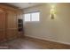 Bedroom featuring wood floors, a large window, and built-in shelving at 3345 E University Dr # 2, Mesa, AZ 85213