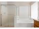Bright bathroom featuring a soaking tub with a large window, and a glass shower at 3550 E Topeka Dr, Phoenix, AZ 85050