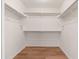Large walk-in closet with hanging racks and wood flooring at 3550 E Topeka Dr, Phoenix, AZ 85050