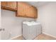 Functional laundry room with overhead cabinets and appliances to make laundry a breeze at 3550 E Topeka Dr, Phoenix, AZ 85050