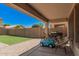 Covered patio with brick flooring leading to a spacious backyard with artificial grass at 3625 W South Butte Rd, San Tan Valley, AZ 85144