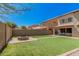 Backyard with artificial grass, a fire pit, and views of the home's exterior at 3625 W South Butte Rd, San Tan Valley, AZ 85144