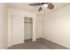 Carpeted bedroom with ceiling fan offers closet with white doors for ample storage at 38191 W Merced St, Maricopa, AZ 85138