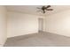 Spacious bedroom with plush carpeting, ceiling fan, and neutral paint color at 38191 W Merced St, Maricopa, AZ 85138