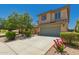 Inviting two-story home featuring manicured landscaping, mature trees, and a two-car garage at 38191 W Merced St, Maricopa, AZ 85138
