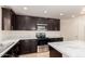 Contemporary kitchen with stainless steel appliances and stylish dark wood cabinets at 38191 W Merced St, Maricopa, AZ 85138