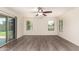 Spacious, well-lit room with wide plank floors, ceiling fan, sliding glass doors, and large windows at 38191 W Merced St, Maricopa, AZ 85138