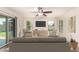 Bright living room with ceiling fan, neutral furniture, and sliding door access to the backyard at 38191 W Merced St, Maricopa, AZ 85138