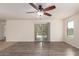 Open living space with modern ceiling fan, wood plank flooring, and access to outdoor patio at 38191 W Merced St, Maricopa, AZ 85138