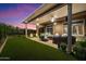 Beautiful backyard featuring a covered patio, comfortable seating, lush lawn, and stunning sunset views at 42105 N Golf Crest Rd, Anthem, AZ 85086