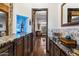 Stylish bar area with stone accents, custom cabinets, and a view into the living space at 42105 N Golf Crest Rd, Anthem, AZ 85086