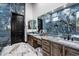 Bathroom with dual sinks, vanity, and large mirror with a view of the custom shower at 42105 N Golf Crest Rd, Anthem, AZ 85086