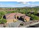 Aerial view of the home showcasing its desert landscaping, tile roof, and golf course views in the distance at 42105 N Golf Crest Rd, Anthem, AZ 85086