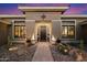Inviting front entrance with stone pathway, desert landscaping, and a welcoming black door at 42105 N Golf Crest Rd, Anthem, AZ 85086