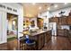 An open-concept kitchen with a large center island, stainless steel appliances, and dark wood cabinets at 42105 N Golf Crest Rd, Anthem, AZ 85086
