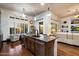Bright kitchen island with sink, dishwasher, and barstool seating with views to seating area at 42105 N Golf Crest Rd, Anthem, AZ 85086