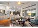 Open-concept living room with a view of the kitchen, large windows, and comfortable seating arrangements at 42105 N Golf Crest Rd, Anthem, AZ 85086