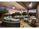 Spacious covered patio with comfortable seating, ceiling fans, and sunset views, perfect for outdoor entertaining at 42105 N Golf Crest Rd, Anthem, AZ 85086