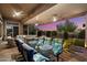 Inviting covered patio featuring ample seating, a glass-top dining table, and picturesque sunset views at 42105 N Golf Crest Rd, Anthem, AZ 85086