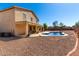 Large backyard boasts a beautiful pool and covered patio for outdoor living, surrounded by gravel landscaping at 42616 W Avella Dr, Maricopa, AZ 85138